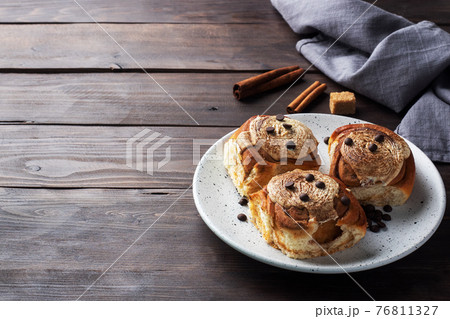 Kanelbulle Cinnamon buns with buttercream on a rustic wooden table. Homemade fresh pastries. 76811327