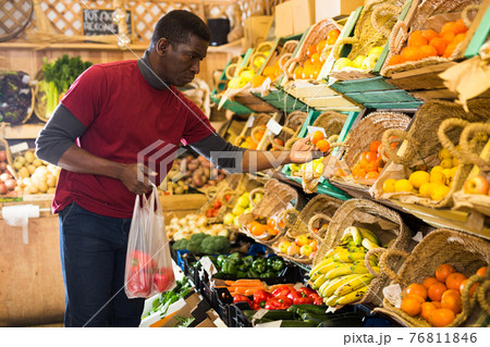 Man looking for vegetables and fruits in greengrocery Man looking for vegetables and fruits in greengrocery 76811846