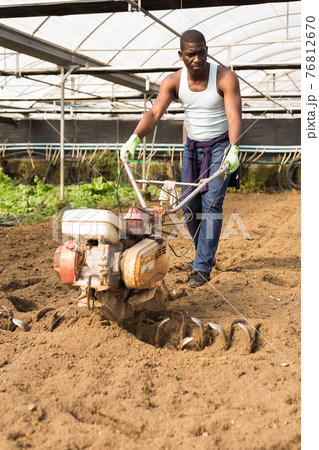 African man plowing ground with cultivator African man plowing ground with cultivator 76812670