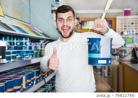 Male customer examining various wall paints 76812760