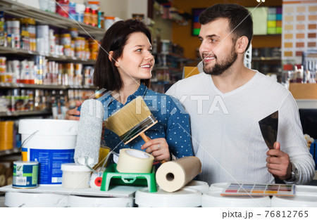 Couple purchasing tools for house improvements in paint supplies store Couple purchasing tools for house improvements in paint supplies store 76812765