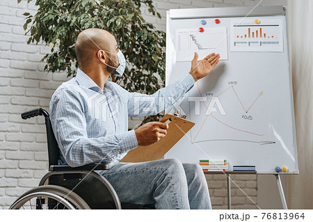 Disabled young man making presentation in office wearing medical mask 76813964