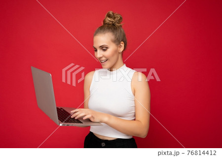 Side profile photo shot of beautiful smiling happy blond young woman with gathered hair wearing Side profile photo shot of beautiful smiling happy blond young woman with gathered hair wearing 76814412