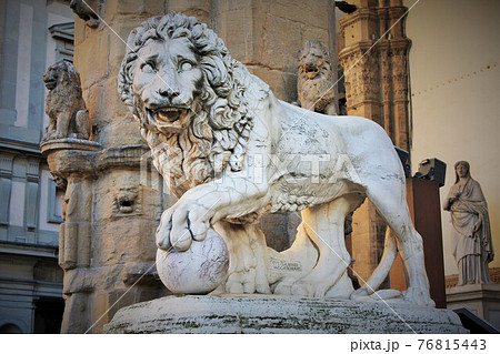 Florence, Tuscany, Italy: ancient statue of a lion in Piazza della Signoria, sculpture that depicts a lion with a sphere under one paw 76815443