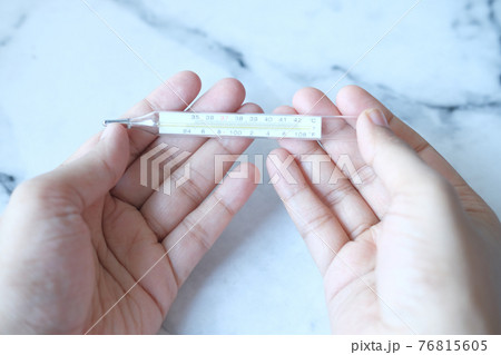 man hand holding medical thermometer man hand holding medical thermometer 76815605