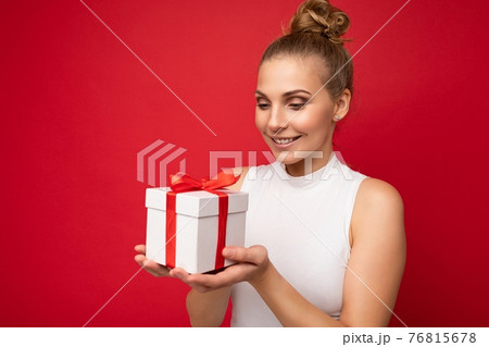 Photo shot of beautiful positive smiling young blonde woman isolated over red background wall 76815678