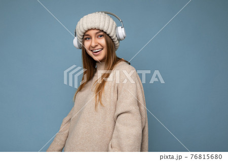 Photo of beautiful happy smiling young blonde woman wearing beige winter sweater and hat isolated 76815680