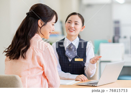 受付で相談する若い女性 受付で相談する若い女性 76815753