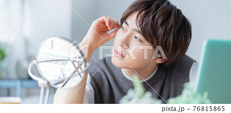 自宅のリビングの鏡の前でヘアスタイルを気にするZ世代　バナーサイズ 76815865