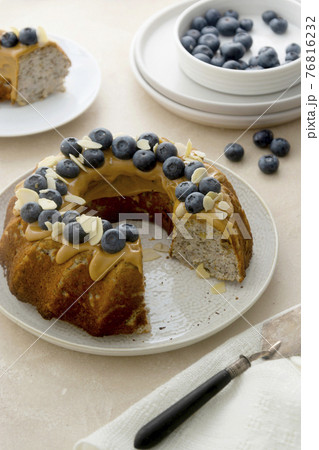Bundt cake with peanut butter glaze. Healthy sugar gluten free cake with chia seeds decorated with blueberries and almond flakes. 76816232