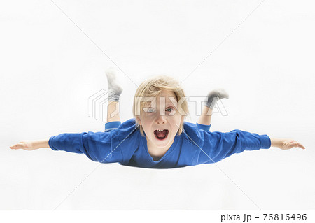 Surprised boy is flying or falling in the air. Free fall. White background Surprised boy is flying or falling in the air. Free fall. White background 76816496