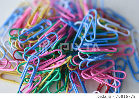 Many multicolored paper clips lying on table closeup 76816778