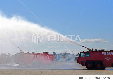 一斉放水中の航空機用化学消防車の写真素材