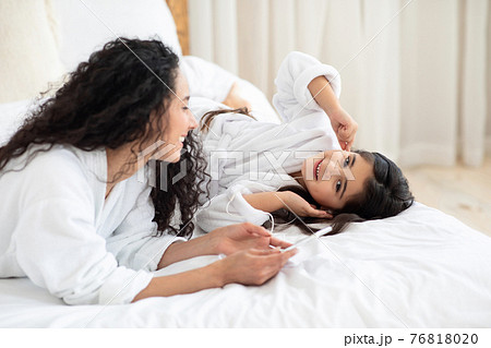 Joyful little girl listening to music, using phone and earphones 76818020