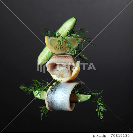 Herring fillet in oil with lemon, cucumber, and dill. 76819156