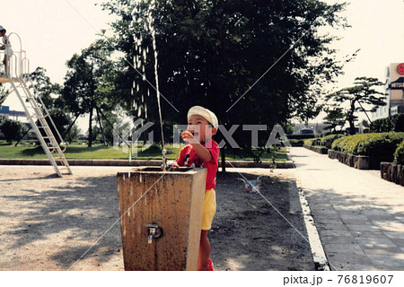 昔のフィルム写真　公園の水飲み場で遊ぶ男の子 76819607