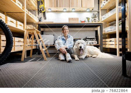 Woman with a dog in the workshop 76822864