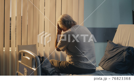 Depressed aged patient sitting on bed Depressed aged patient sitting on bed 76823368
