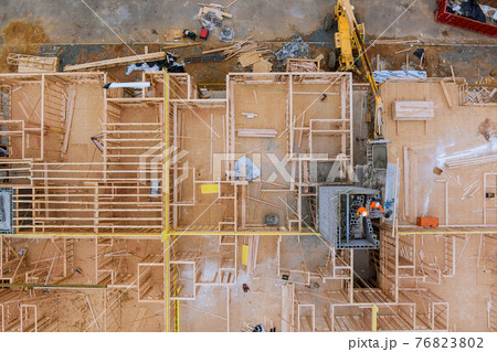 Aerial view of masonry brick builders are building walls in elevator shaft on under construction 76823802