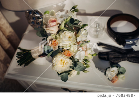 wedding bouquet with roses and boutonniere.The decor at the wedding 76824987