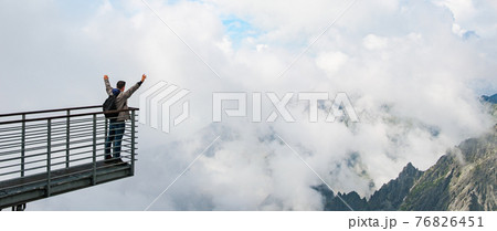 Tourist enjoying of amazing view of mountains and clouds. View from Lomnicky peak in Slovakia. Sport, hiking and active life concept. 76826451