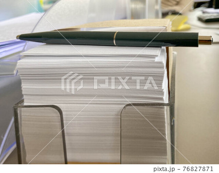 Small square pieces of paper for notes and notes on the office desk and a green ballpoint pen. Business work 76827871