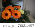 鏡の前の置かれたオレンジのガーベラの花束 76831457