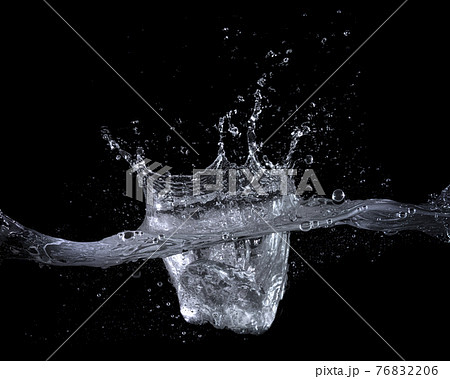 水面に落下した氷。水しぶきの上がった瞬間のテクスチャー　黒背景 76832206