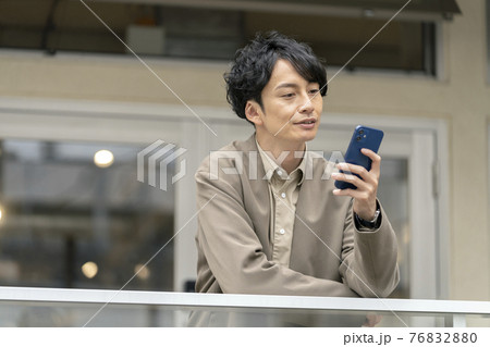 スマートフォンの画面を見る30代の男性 スマートフォンの画面を見る30代の男性 76832880