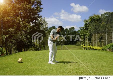Golfer playing golf in the evening golf course, on sun set evening time. Man playing golf on a golf course in the sun. Golfer playing golf in the evening golf course, on sun set evening time. Man playing golf on a golf course in the sun. 76833487