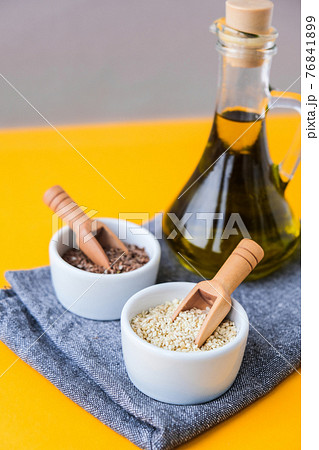 Sesame and flax seeds wooden spoons with oil in glass bottle. Healthy food concept. Vegan keto diet. Linseed oil. Sesame oil Minimalistic concept in isometric style in trendy colors. 76841899