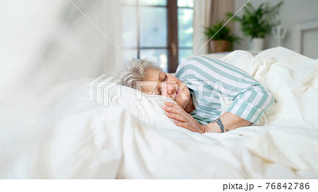 Happy senior woman in bed at home, sleeping. Happy senior woman in bed at home, sleeping. 76842786