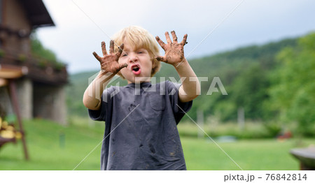 Small boy with dirty hands standing in vegetable garden, sustainable lifestyle. Small boy with dirty hands standing in vegetable garden, sustainable lifestyle. 76842814