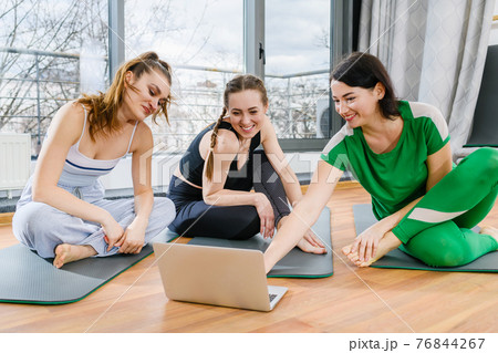 Girls in sportswear look at laptop screen Girls in sportswear look at laptop screen 76844267