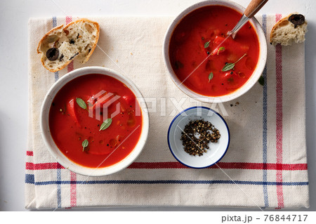 Tomato soup in a white bowl on white background. Top view. Copy space Tomato soup in a white bowl on white background. Top view. Copy space 76844717