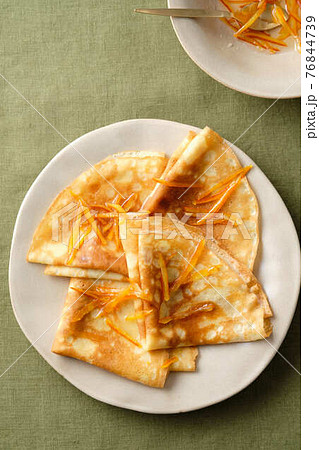 Crepes suzette with orange sauce and zest. 76844739
