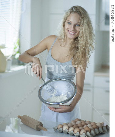 Portrait of woman mixing cookie batter in kitchen at counter 76845821