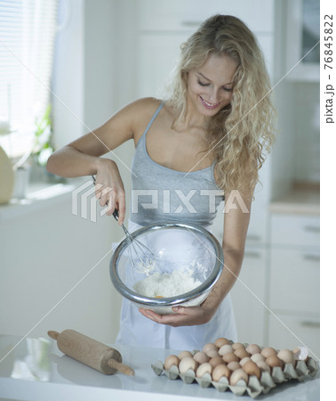 Woman mixing cookie batter in kitchen at counter Woman mixing cookie batter in kitchen at counter 76845822