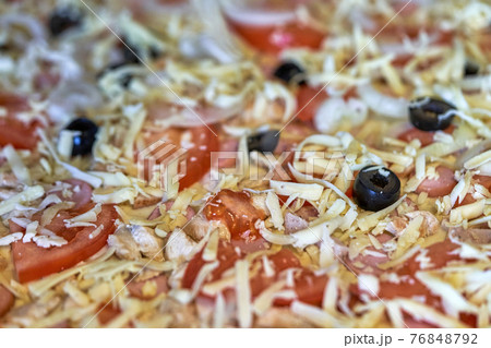 Fragment of raw pizza with tomatoes, cheese and olives, background and texture Fragment of raw pizza with tomatoes, cheese and olives, background and texture 76848792