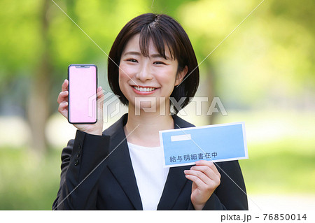 スマートフォンと給与明細を持つ女性 スマートフォンと給与明細を持つ女性 76850014