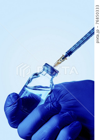 person fills a syringe with a vaccine person fills a syringe with a vaccine 76850333