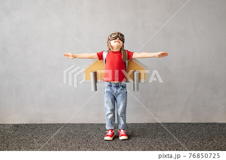 Happy child playing with toy paper wings 76850725