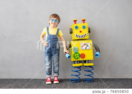 Happy child playing with toy paper robot 76850850