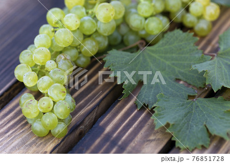 White wine grape on wooden background. harvest time White wine grape on wooden background. harvest time 76851728