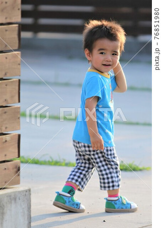 散歩中笑顔で振り向く2歳の男の子 76851980