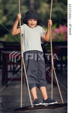 Boy having fun on the swing Boy having fun on the swing 76852234