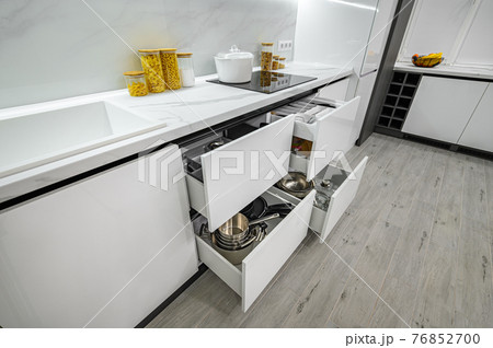 Luxurious white and black modern kitchen interior, drawers pulled out 76852700