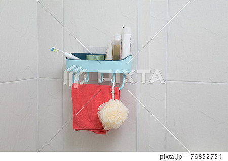 bathroom shelf with bathroom accessories against the tile wall 76852754
