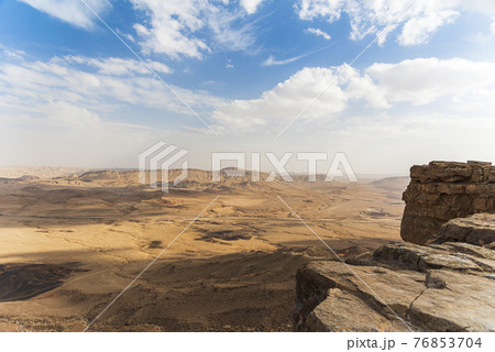 Ramon Crater Makhtesh Ramon, the largest in the world, as seen from the high rocky cliff edge surrounding it from the north, Ramon Nature reserve, Mitzpe Ramon, Negev desert, Israel 76853704