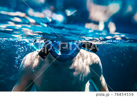 Man in snorkeling mask underwater swimming Man in snorkeling mask underwater swimming 76854559